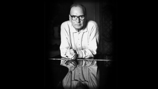 Ennio Morricone is sitting with folded hands and reflection on a glossy surface, HD Desktop Wallpaper