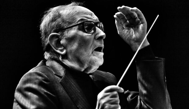 Ennio Morricone is shown passionately conducting an orchestra in this black and white image, 2K Desktop Wallpaper