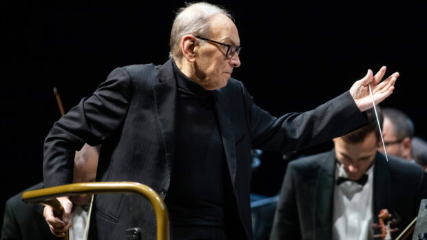 Ennio Morricone is conducting an orchestra during a live performance, 4K Desktop Wallpaper