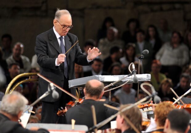 Ennio Morricone is seen conducting a full orchestra during a live performance, 2K Desktop Wallpaper
