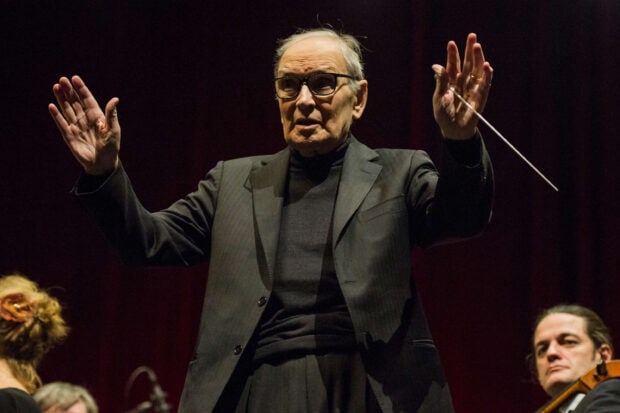 Ennio Morricone is conducting an orchestra during a live performance, 2K Desktop Wallpaper
