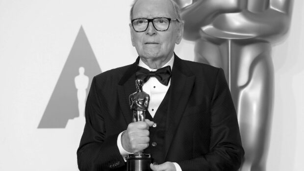 Ennio Morricone holding an Oscar statue at an award ceremony, HD Desktop Wallpaper