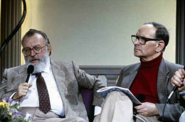 Ennio Morricone is speaking while another person listens carefully during the interview, HD Desktop Wallpaper
