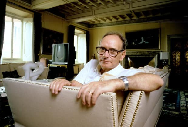 A man with glasses is sitting on a beige sofa in a classic tiled room, HD Desktop Wallpaper