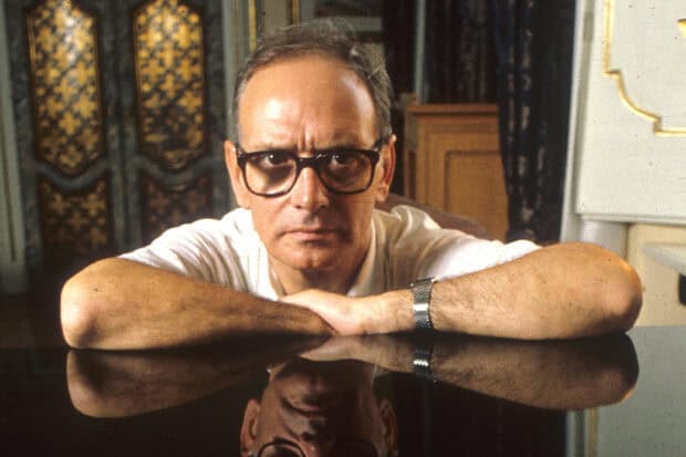 Ennio Morricone is resting his arms on a reflective surface in this image, HD Desktop Wallpaper