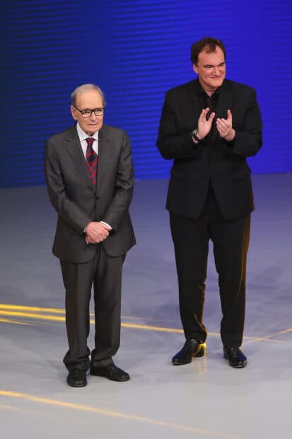 Ennio Morricone stands beside Quentin Tarantino on a stage during an event, 2K Mobile Wallpaper