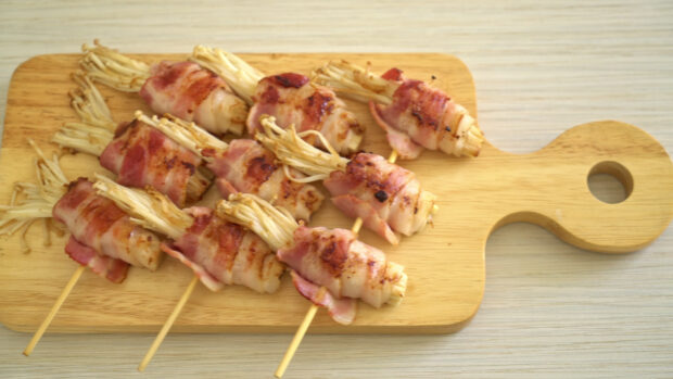 Grilled enoki mushrooms wrapped in bacon are arranged on a wooden board, 4K Desktop Wallpaper