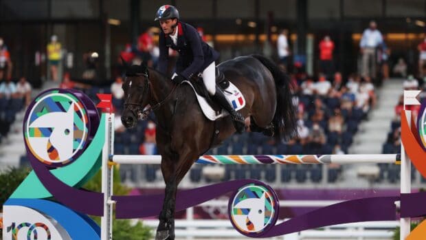 A rider competes in eventing with a horse jumping an obstacle in a stadium, 2K Desktop Wallpaper