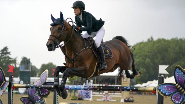 A rider competes in an eventing competition jumping over a brightly decorated obstacle, HD Desktop Wallpaper