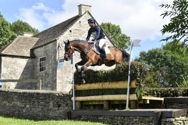 A rider on a horse jumping over an obstacle in an eventing competition, HD Desktop Wallpaper