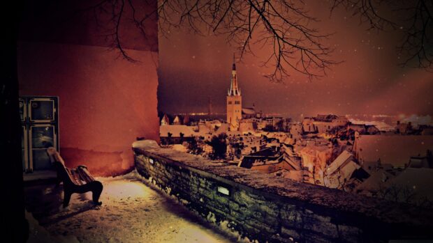 A snowy view of Estonia cityscape with illuminated buildings at night, 4K Desktop Wallpaper