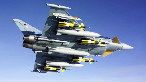 A Eurofighter jet is shown flying with yellow missiles attached to the wings, HD Desktop Wallpaper