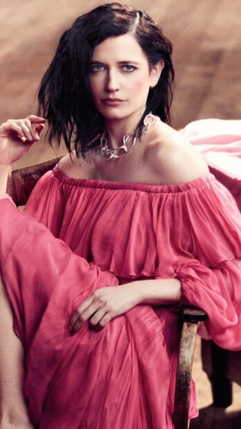 Eva Green wears a pink flowing dress sitting on a wooden chair with a serious expression, 4K Phone Wallpaper