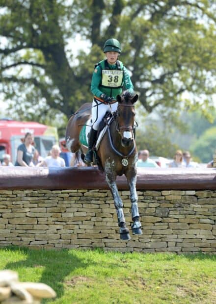 A rider is jumping a horse over a stone obstacle during eventing competition, HD Mobile Wallpaper