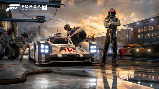 A racing game scene shows a detailed car and driver in the pit stop area during sunset, HD Desktop Wallpaper