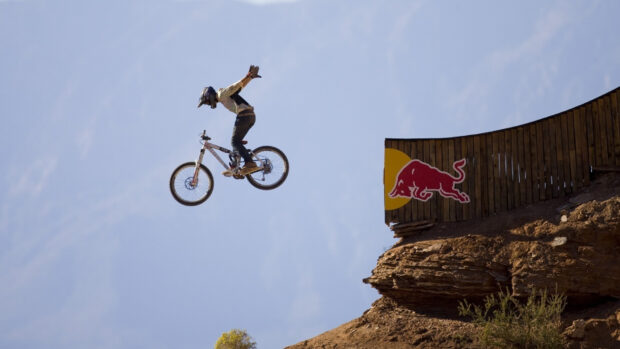 A BMX rider performs a high jump over a ramp during a sports event, HD Desktop Wallpaper