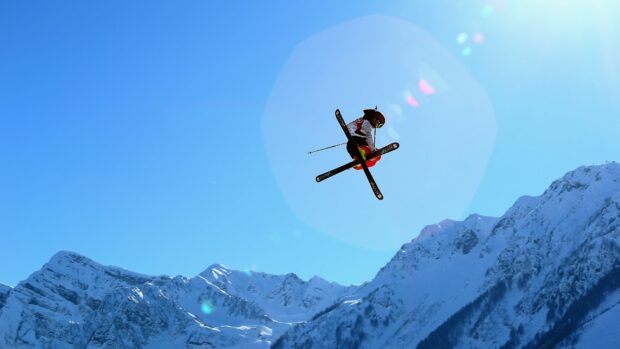 A skier performs a high jump over snowy mountains with clear blue sky, HD Desktop Wallpaper