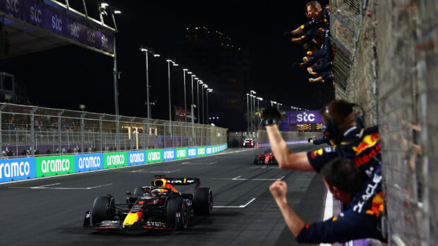 A Red Bull F1 car crosses the finish line with team members cheering beside the track, HD Desktop Wallpaper