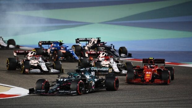 F1 race cars compete closely during a night race on the circuit, HD Desktop Wallpaper