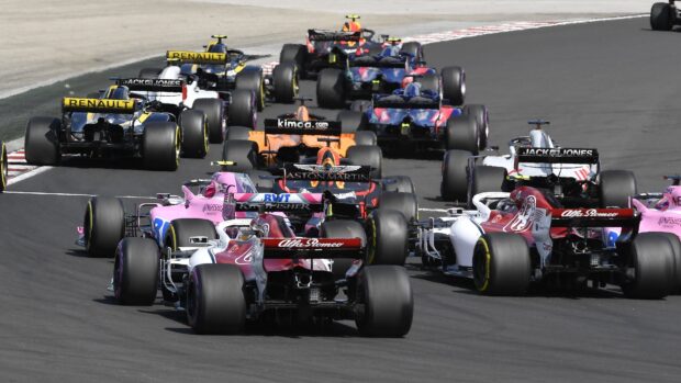 A group of F1 race cars competes closely on a racing circuit during a high speed event, 4K Desktop Wallpaper