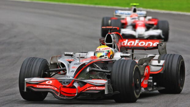 An F1 race wallpaper showing two cars competing on a circuit, HD Desktop Wallpaper
