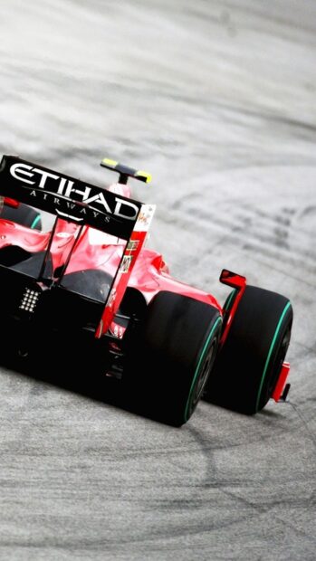 A red F1 racing car speeds on a gray asphalt track during the race, HD Phone Wallpaper