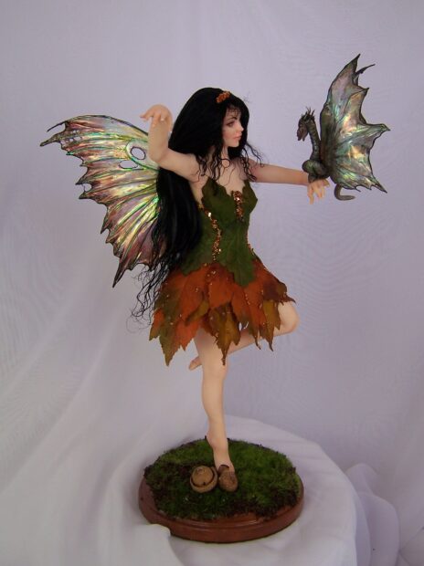 A fairy with autumn leaves dress holds a small dragon in her hand, HD Mobile Wallpaper