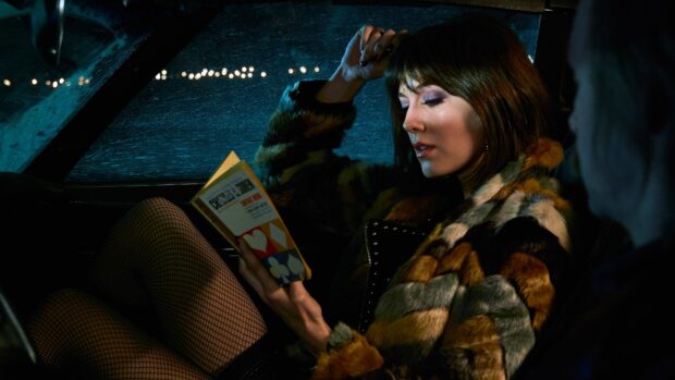 A woman in a fur coat reads a book inside a car during nighttime in Fargo Wallpapers, 4K Desktop Wallpaper