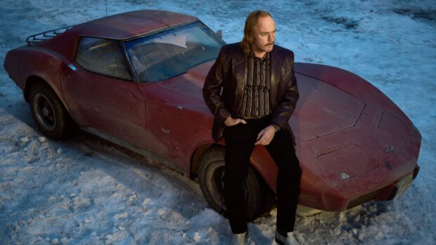 A man leans on a red vintage car in a snowy setting with Fargo wallpapers theme, 4K Desktop Wallpaper