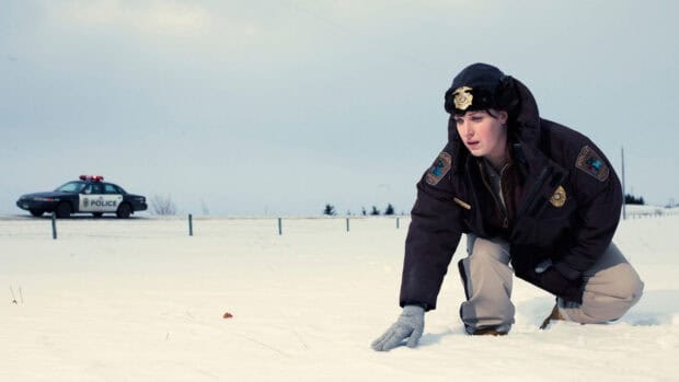 A police officer inspects snow at a Fargo crime scene with a patrol car nearby, HD Desktop Wallpaper