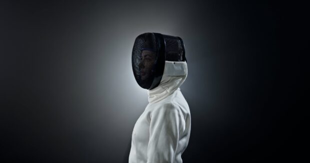 A fencer is wearing a white protective suit and mask in a focused stance, 4K Desktop Wallpaper