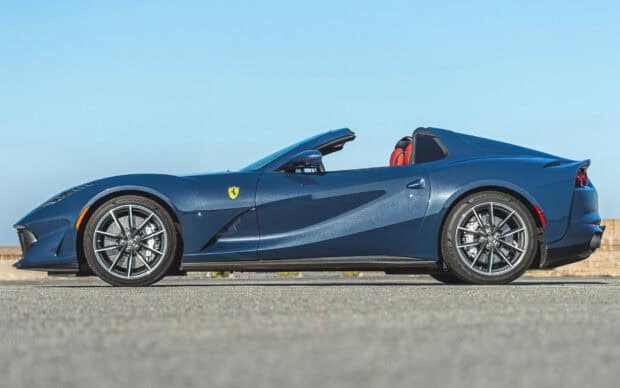 A blue Ferrari 812 Gts convertible is parked on a road with a clear sky in the background, HD Desktop Wallpaper