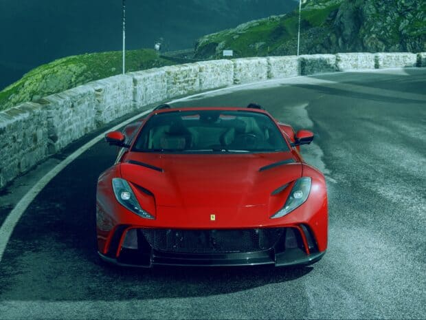 A red Ferrari 812 Gts is parked on a winding mountain road with stone barriers, HD Desktop Wallpaper