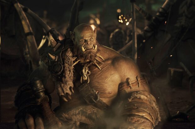 A fierce orc warrior wearing tribal armor in a smoky battlefield, HD Desktop Wallpaper