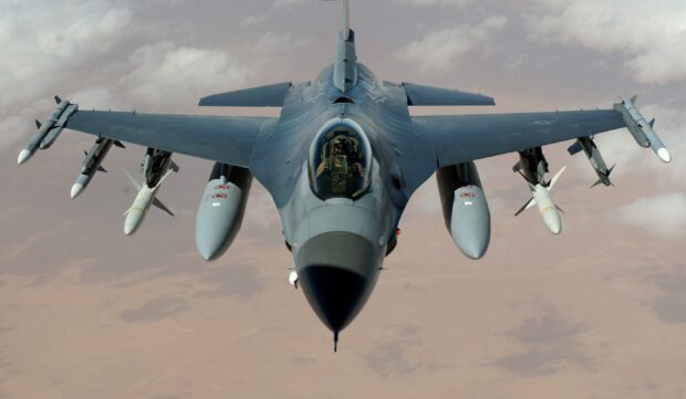 A jet fighter with missiles is flying over a desert landscape, 2K Desktop Wallpaper