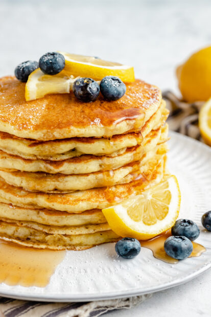A stack of fluffy pancakes topped with lemon slices and blueberries on a white plate, HD Phone Wallpaper