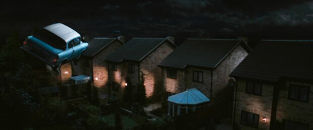 The Chamber Of Secrets Wallpapers shows a flying car above quiet houses on a dark night, 4K Desktop Wallpaper