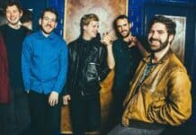 Foals band members pose casually in a vibrant indoor setting, HD Desktop Wallpaper