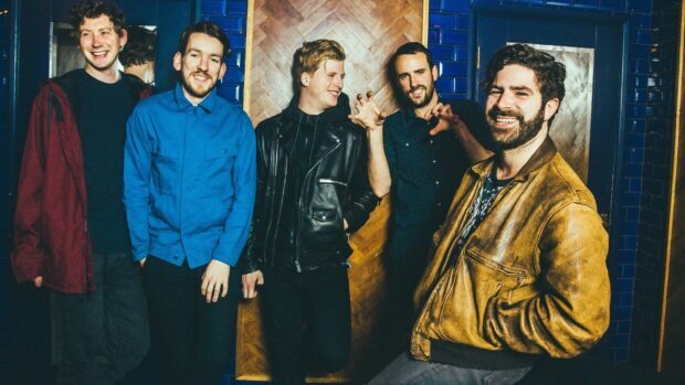 Foals band members pose casually in a vibrant indoor setting, HD Desktop Wallpaper