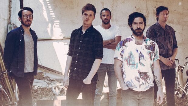 The Foals Band members stand together in an outdoor setting with sunlight and shadows, HD Desktop Wallpaper