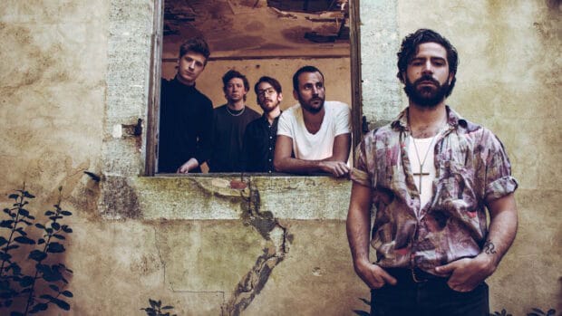 The Foals band poses together near an old textured beige wall showing a relaxed mood, HD Desktop Wallpaper
