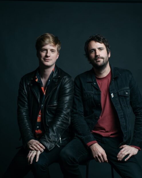 Two men from Foals band posing together in dark clothing, HD Desktop Wallpaper