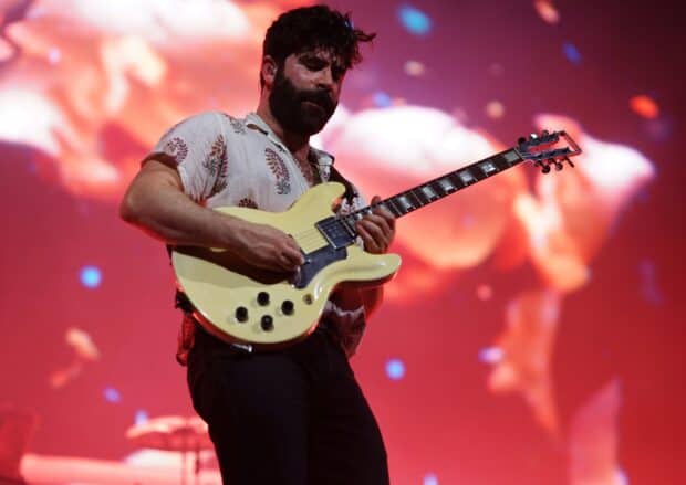 A Foals band member is playing an electric guitar during a concert, 2K Desktop Wallpaper