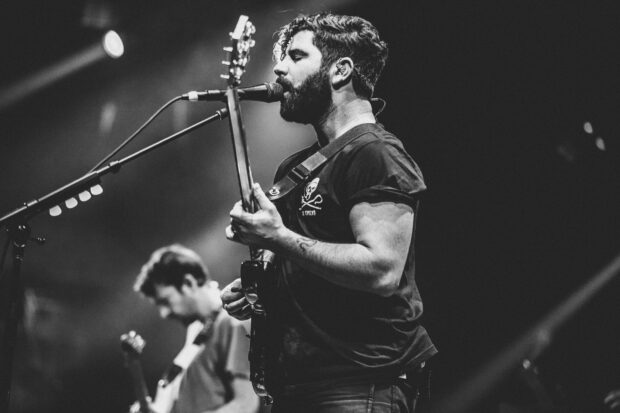 A Foals band member sings and plays guitar during a live performance, HD Desktop Wallpaper