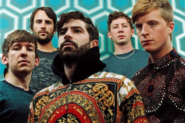 The Foals band stands confidently in front of a vibrant geometric patterned wall, Foals Band Wallpapers, HD Desktop Wallpaper