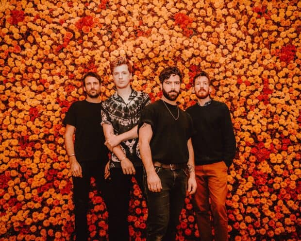Foals band stands together against a background of vibrant orange and red flowers, HD Desktop Wallpaper