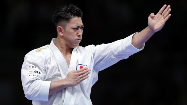 A focused karate fighter performs a precise hand technique during a competition, 2K Desktop Wallpaper