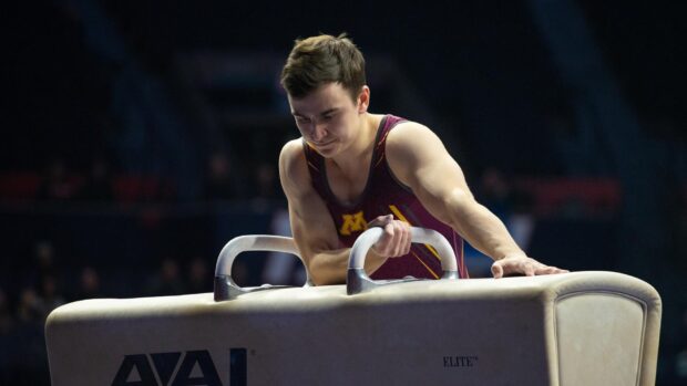 A male gymnast concentrates intensely during a pommel horse routine at a competition, HD Desktop Wallpaper