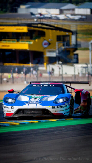 A Ford race car is captured speeding on a colorful race track during a competition event, HD Phone Wallpaper