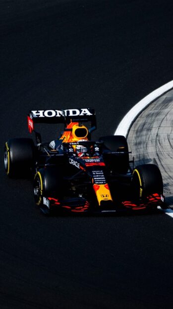 A Formula 1 racing car speeds along the curve of a race track during a high speed race event, HD Phone Wallpaper